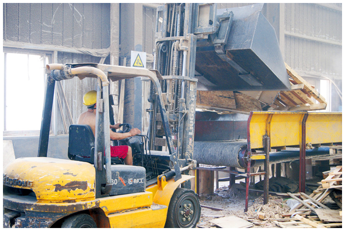 工人正在给破碎机加料,全流水线机械作业